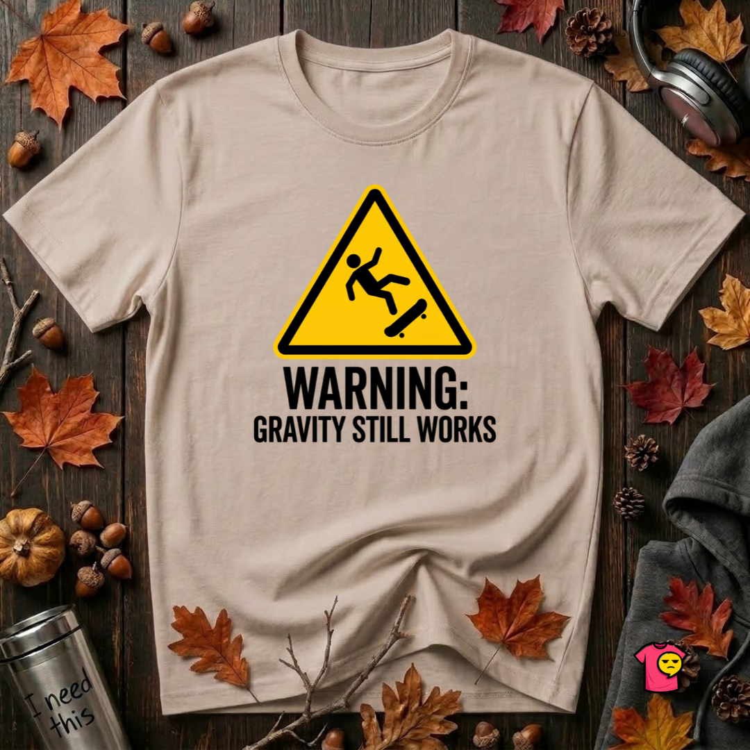 Warning Gravity Still Works sarcastic graphic t-shirt in Natural by Snarky Sarks