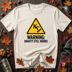 Warning Gravity Still Works sarcastic graphic t-shirt in White by Snarky Sarks
